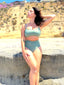 Green swimsuit set with hidden-support top and mid-rise bottom, worn on a sandy beach; fresh, supportive swimwear look.